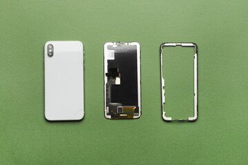 Disassembled mobile phone on color background