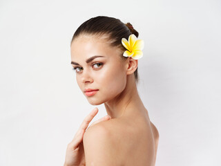 woman with bare shoulders face makeup yellow flower cropped view