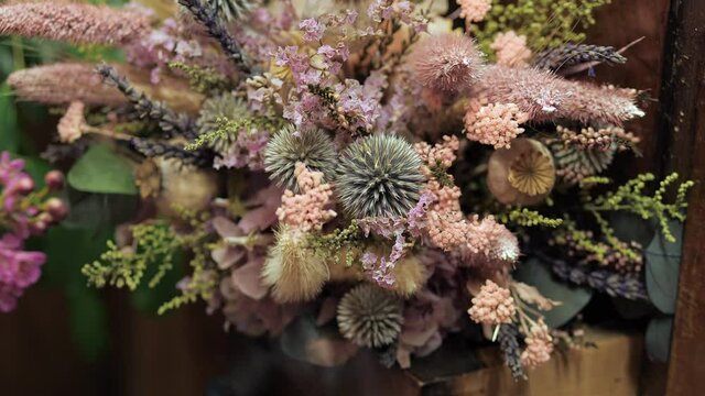 Bouquet of dried flowers. Floral arrangement of dry flowers like echinops. Flower shop assortment.