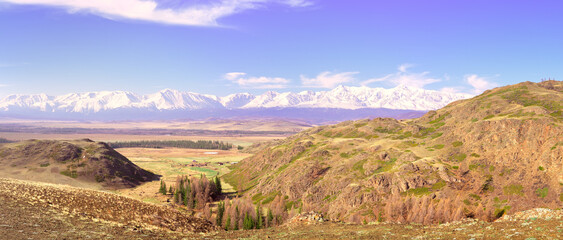 The North-Chui range in the Altai Mountains. A rocky valley in the Kurai steppe, snow-capped mountains in the distance under a blue sky. Pure Nature of Siberia, Russia