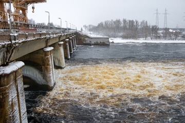 Water flow at a hydroelectric power station on a frosty winter day