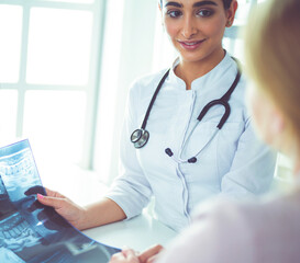 Female doctor giving a consultation to a patient and explaining medical informations and diagnosis