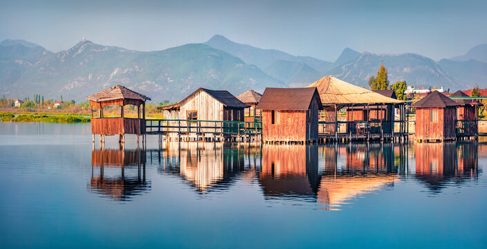 Panoramic morning view of fishing dock on popular tourist attraction Patocut Laguna. Calm morning seascape of Adriatic sea, Albania, Europe. Traveling concept background..