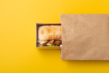Sandwich in takeout or delivery food container and paper bag
