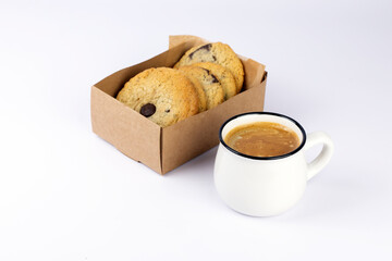 Hot black coffee with foam and sweet chocolate cookies in kraft paper box on white background. Part of set.