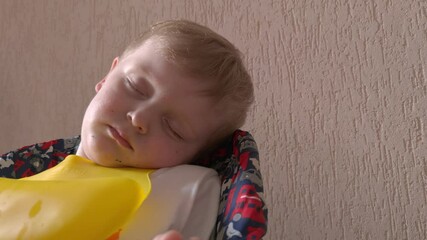 Boy sleeping sitting child daytime sleep in a highchair