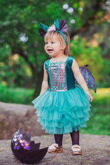adorable baby in a dragon costume that has just hatched from an egg