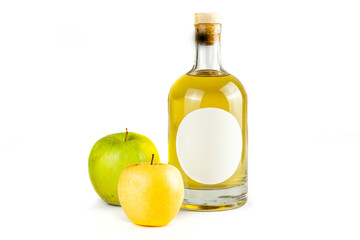 Fresh apples and bottle with fruit brandy. Bottle with oval label, amber liquid and various color apples isolated on white background. Homemade fruit alcohol concept.