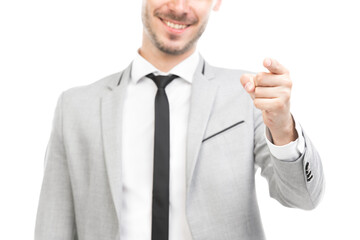 Horizontal shot of handsome young adult Caucasian man wearing gray suit pointing finger at camera, white background
