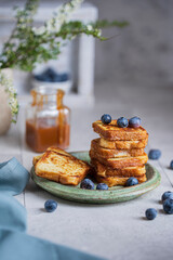 Homemade French toasts with berries, caramel on white table. Beautiful breakfast or dessert. Studio image with copy space, bright rustic background.