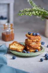 Homemade French toasts with berries, caramel on white table. Beautiful breakfast or dessert. Studio image with copy space, bright rustic background.