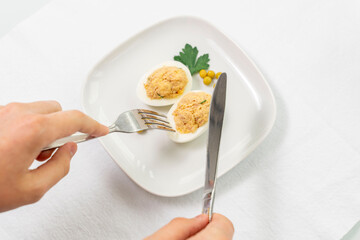 stuffed eggs with canned tuna and herbs. man is ready to taste food