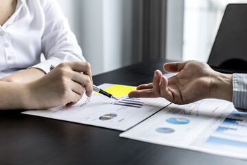 Two businessmen pointed to the material for the meeting, working together to plan to develop and solve common business problems. Concept of business management for growth and quality.