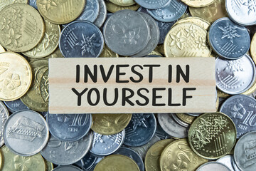 Text sign showing Invest In Yourself on wooden block with coin background. Business plan concept.