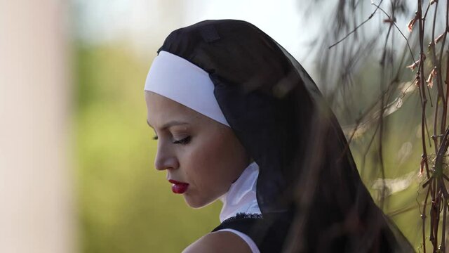 sexy lady in image of depraved catholic nun, image for halloween, closeup portrait outdoors