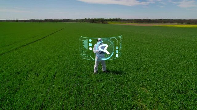 A scientist, a farmer conducts research on a farmland using augmented reality. Future-proof tools for cultivating plants, modern management of an agricultural enterprise.