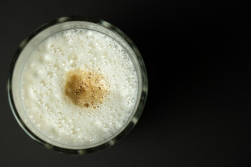 Glass of latte coffee on black background