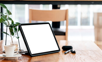 Mockup blank screen tablet and gadget on wooden table with copy space.