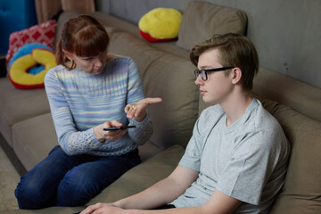 Mother son teenager talking at home family relationship on the couch. High resolution photos