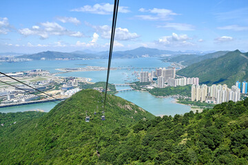 Bird's eye view of deep blue sea and green mountain at Ngong Ping cable car, Lantau Island, Hong...