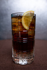 Cold lemonade with lemon and ice in a glass