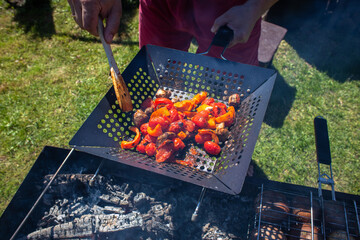 Fresh vegetables are grilled. Man stirring grilled vegetables with a wooden spatula