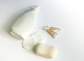 Fototapeta na wymiar white lotion dispenser, soap bar, cotton swabs, cotton pads, bathroom supplies on white background