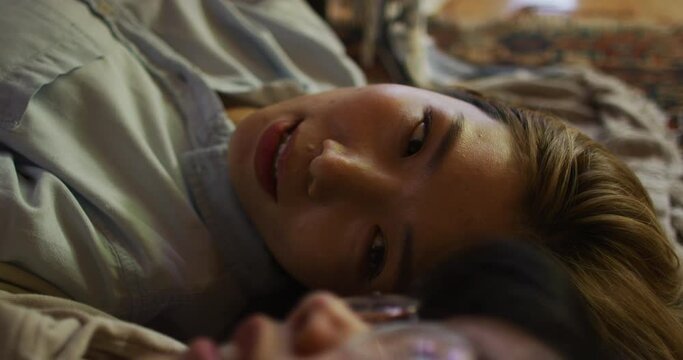 Close Up Of Asian Mother And Daughter Lying Under Blanket Fort At Home