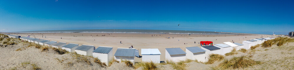 Panoramic view from a dune on the beach of Nieuwpoort with strand cabins in the foreground on a sunny springday © fotografiemahieu