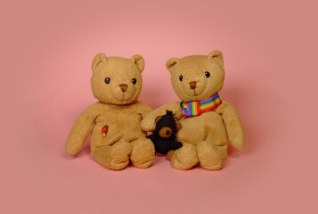 Gay pride - gay couple bears and baby bear with rainbow sign on a pink background