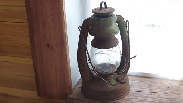 Old metal kerosene lamp on the window. Museum exhibit, close-up