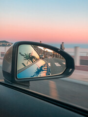 Car mirror reflection with a sunset