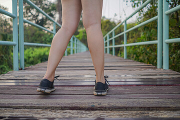 Female runners standing on the suspension bridge, wooden floor, light green steel grips. Located in Thailand