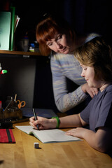 Fototapeta premium Photo of a boy doing homework at the table with mom. High resolution photos