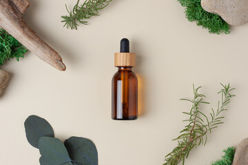 Cosmetic bottle with eucalyptus and wood on beige background. Flat lay.