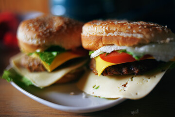 Photos of homemade burgers. Steak and white bun with sesame seeds, cheese and cabbage, tomatoes. Homemade food.