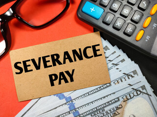 Business concept.Text SEVERANCE PAY with banknote,calculator and glasses on red and black background.