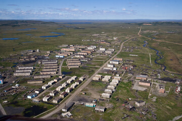 Fototapeta na wymiar Aerial view of a northern town in the Arctic. There are many abandoned buildings in the settlement. Top view of the streets and houses in the tundra. Ugolnye Kopi, Chukotka, Siberia, Far East Russia.