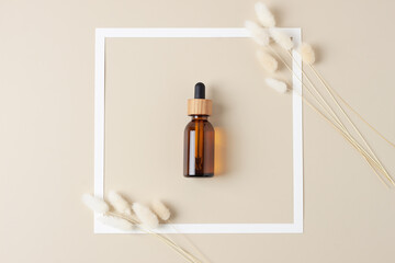 White frame with cosmetic bottle on beige background. Flat lay.