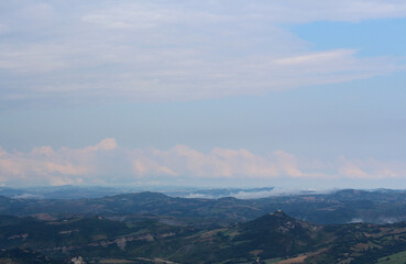 Fototapeta na wymiar Beautiful landscape with mountainous terrain and cloudy skies. Panoramic view of Italy from San Marino