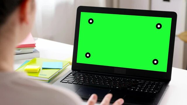 distant education, remote job and people concept - happy smiling female teacher with green screen on laptop computer having online class or video call at home office