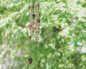 Wind chime with wooden herat shape hanging in the garden,