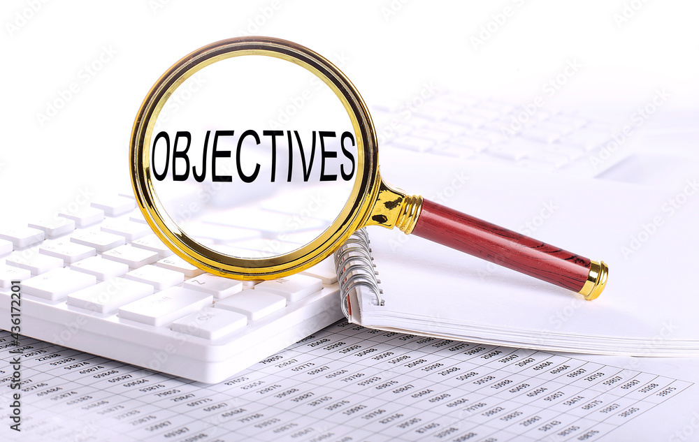 Poster objectives word through magnifying glass on keyboard on the chart