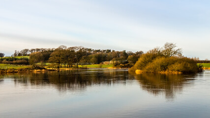 Fototapeta na wymiar Reflection on the River Dee from Lamb Island on Threave Estate, Scotland