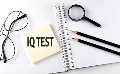 Word IQ TEST on sicker on notebook with pencils,magnifier and glasses