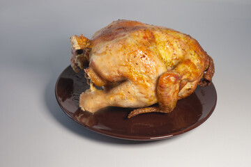 The whole ready-made fried mouthwatering chicken lies on a plate