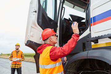 Fototapeta premium Bauarbeiter gibt LKW Fahrer eine Anweisung