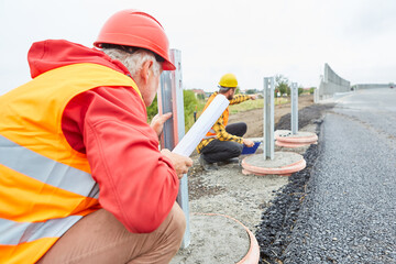 Bauarbeiter bei Kontrolle der Leitplanken Konstruktion