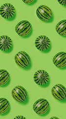 Geometrical pattern of fresh watermelons isolated on a bright green background. Creative food concept. Minimal summer fruit idea. Flat lay, top view.