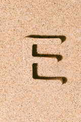 Letter E of the sand isolated on the beach sand. concept of summer. alphabet.